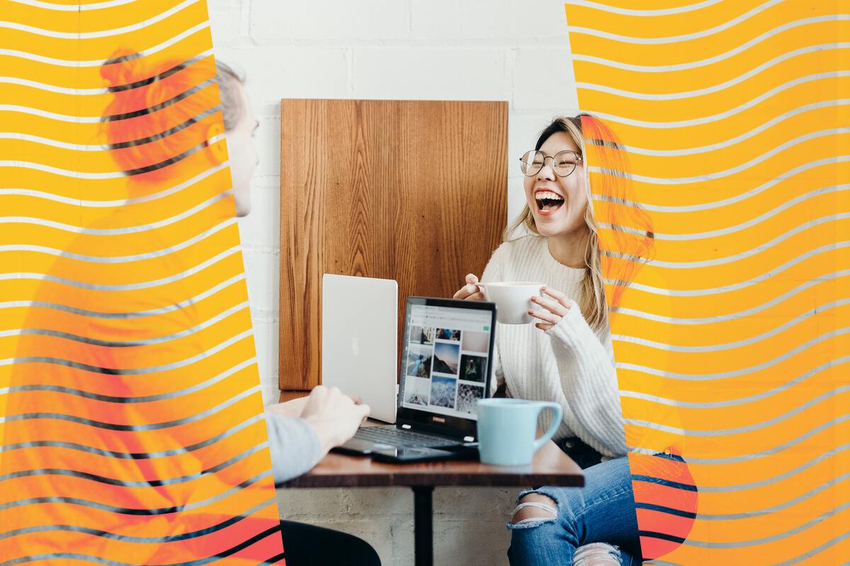 Two students on computers laughing